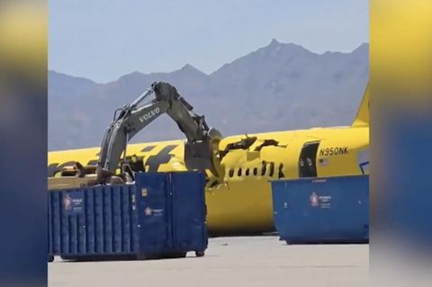 Ein Bagger zerstört ein Flugzeug.