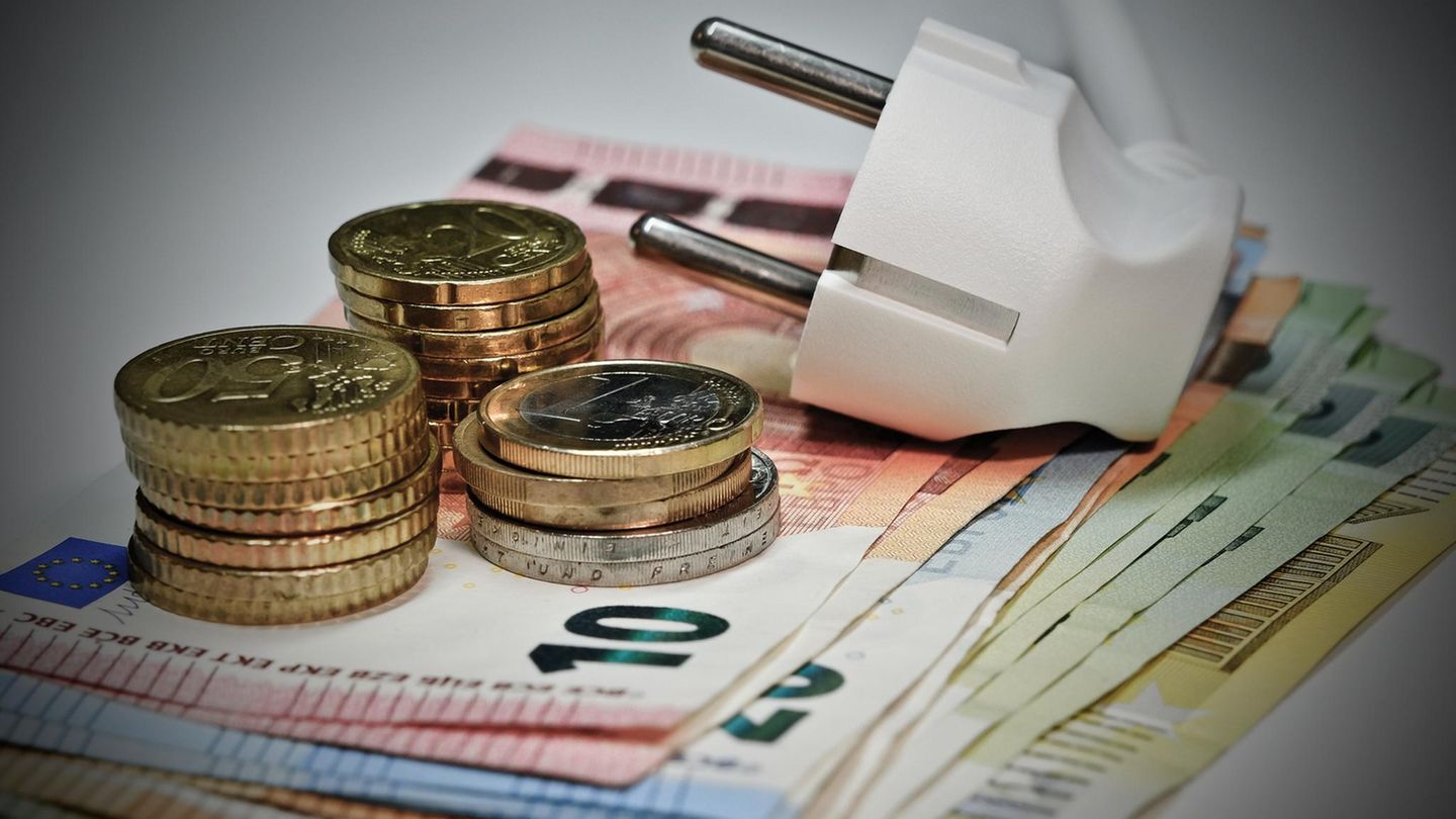Sich mit Balkonkraftwerken unabhängig von Strompreisen machen: Stromkabel liegt auf Geldscheinen.