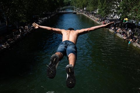 Paris, Frankreich. Obwohl es untersagt ist und die Polizei am Ufer steht, hüpft die Jugend der Stadt zur Abkühlung unverdrossen in den Canal Saint-Martin – bei Temperaturen von mehr als 30 Grad auch kein Wunder.