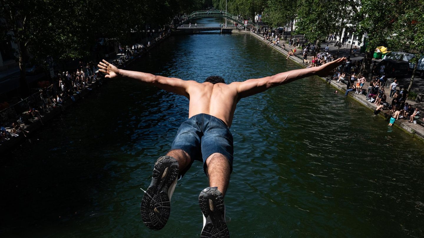 Paris, Frankreich. Obwohl es untersagt ist und die Polizei am Ufer steht, hüpft die Jugend der Stadt zur Abkühlung unverdrossen in den Canal Saint-Martin – bei Temperaturen von mehr als 30 Grad auch kein Wunder.