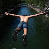 Paris, Frankreich. Obwohl es untersagt ist und die Polizei am Ufer steht, hüpft die Jugend der Stadt zur Abkühlung unverdrossen in den Canal Saint-Martin – bei Temperaturen von mehr als 30 Grad auch kein Wunder.