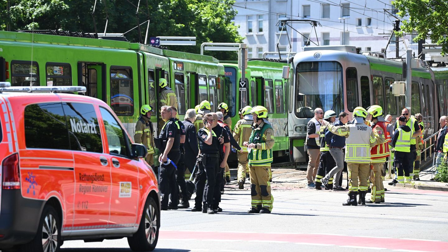 Einsatzkräfte von Polizei und Feuerwehr stehen nach einem Unfall neben zwei Stadtbahnen. Foto: Julian Stratenschulte/dpa