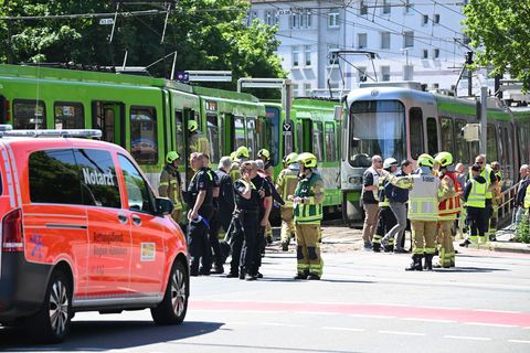 Einsatzkräfte von Polizei und Feuerwehr stehen nach einem Unfall neben zwei Stadtbahnen. Foto: Julian Stratenschulte/dpa