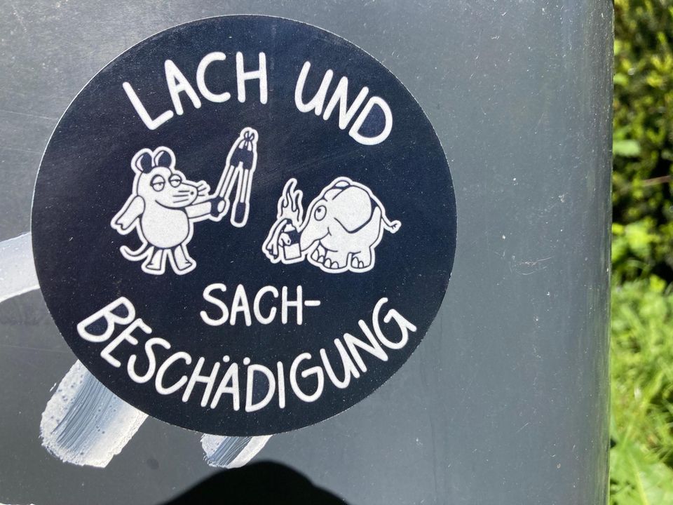 Aufkleber mit Maus und Elefant und dem Satz "Lach- und Sachbeschädigung"