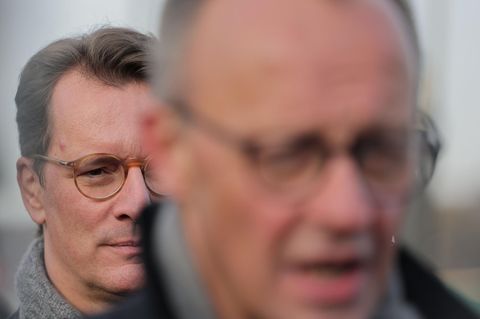 Bundeskanzler Friedrich Merz (vorne, unscharf) und dahinter NRW-Ministerpräsident Hendrik Wüst