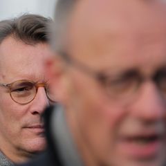 Bundeskanzler Friedrich Merz (vorne, unscharf) und dahinter NRW-Ministerpräsident Hendrik Wüst