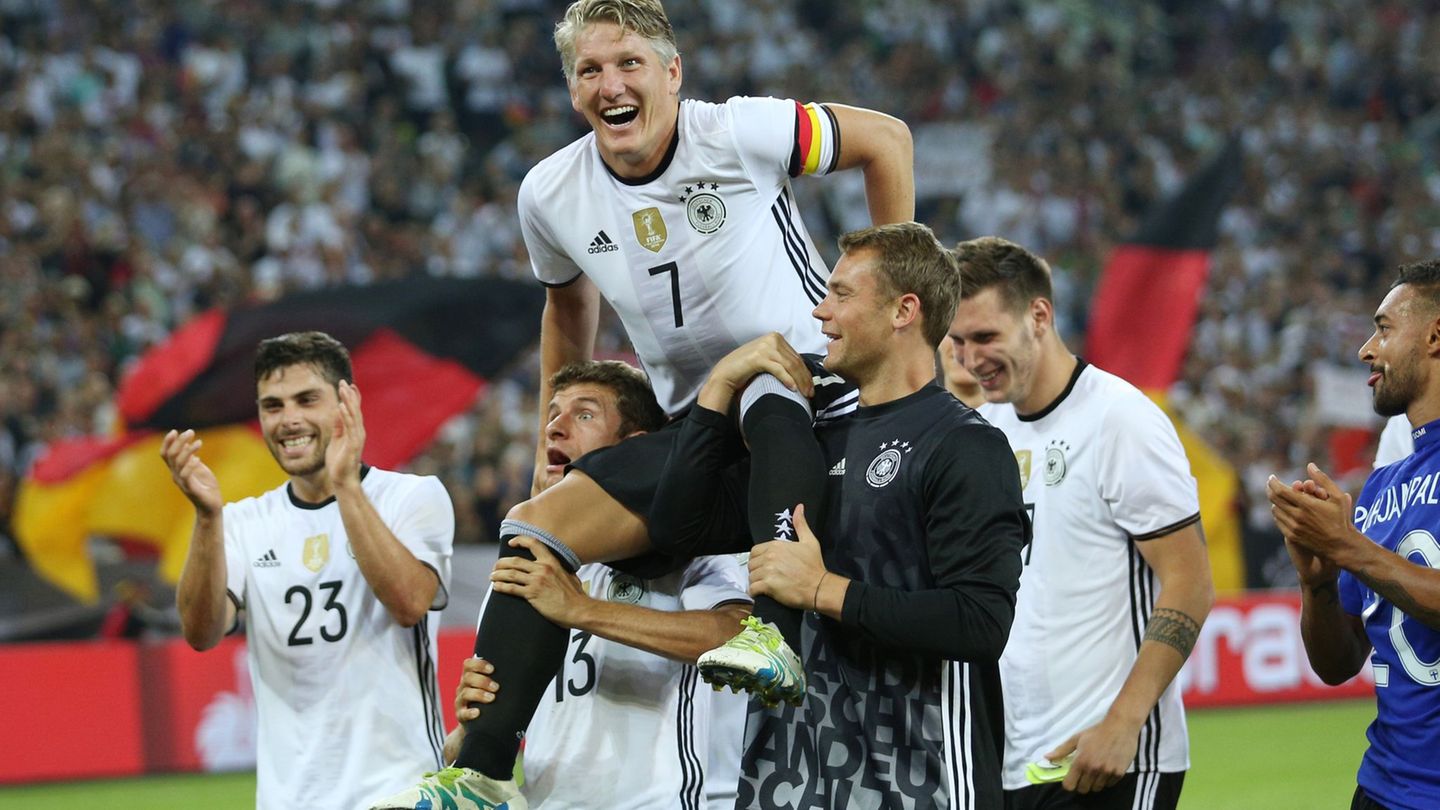 Bastian Schweinsteiger wird nach seinem letzten Länderspiel gegen Finnland von Thomas Müller (l) und Manuel Neuer (r) auf Schult