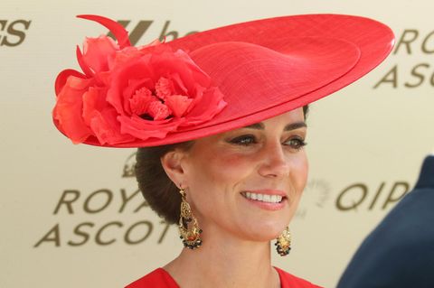 Prinzessin Kate trägt einen roten Hut und lacht in die Kamera