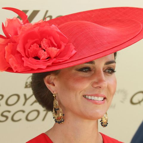 Prinzessin Kate trägt einen roten Hut und lacht in die Kamera