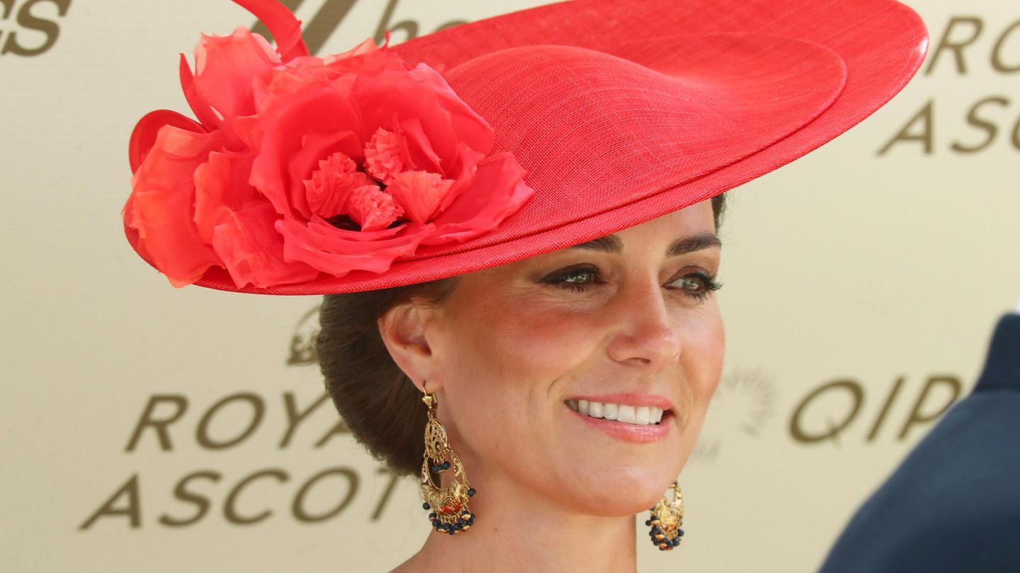 Prinzessin Kate trägt einen roten Hut und lacht in die Kamera
