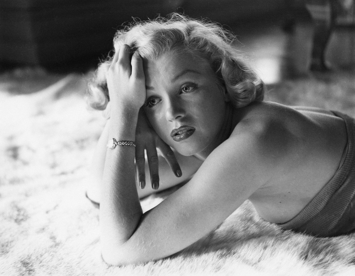 Marilyn Monroe liegt auf einem Tepich, schwarz-weiß Bild und Cose-Up zum Gesicht