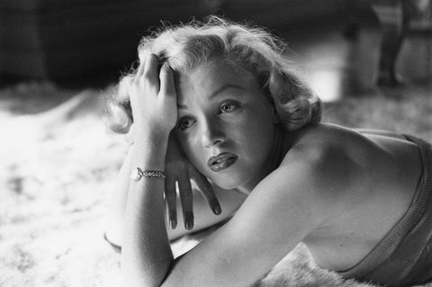 Marilyn Monroe liegt auf einem Tepich, schwarz-weiß Bild und Cose-Up zum Gesicht