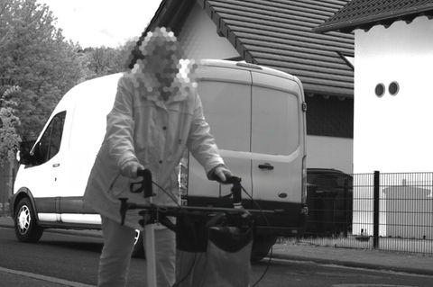 Ein Kastenwagen fährt an einer Frau mit Rollator vorbei