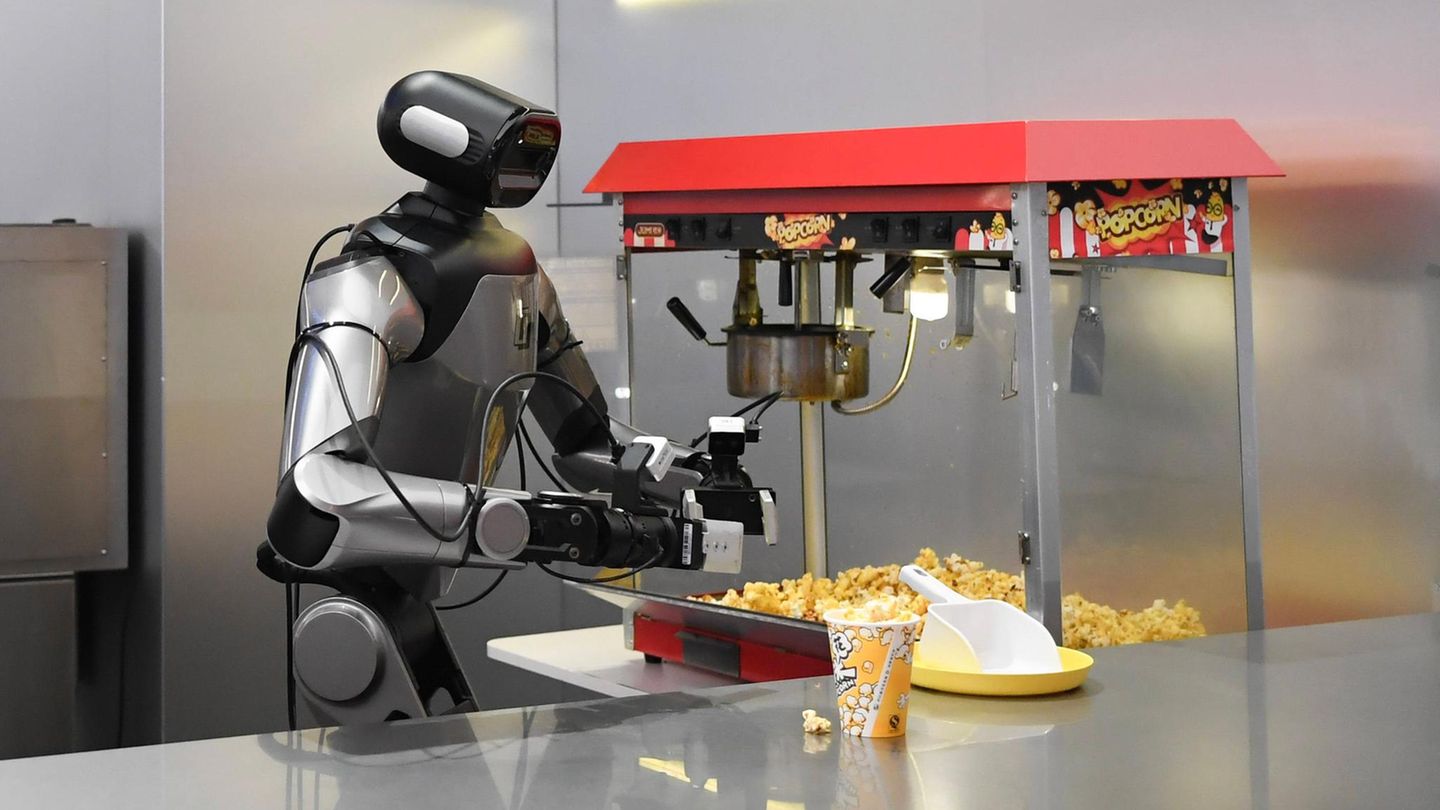 Hangzhou, China. Ein Roboter bereitet für die Besucher einer Ausstellungshalle der chinesischen „nationalen Pilotbasis für verkörperte KI“ vollautomatisiert Popcorn zu. Die Forschungsbasis im ostchinesischen Hangzhou ist eine der wichtigsten für Künstliche Intelligenz. Hier sind derzeit mehr als 130 Roboter in 30 beruflichen Szenarios eingesetzt, die eigentlich von Menschen übernommen werden. Darunter Gastronomie, Einzelhandel und Obsternten.
