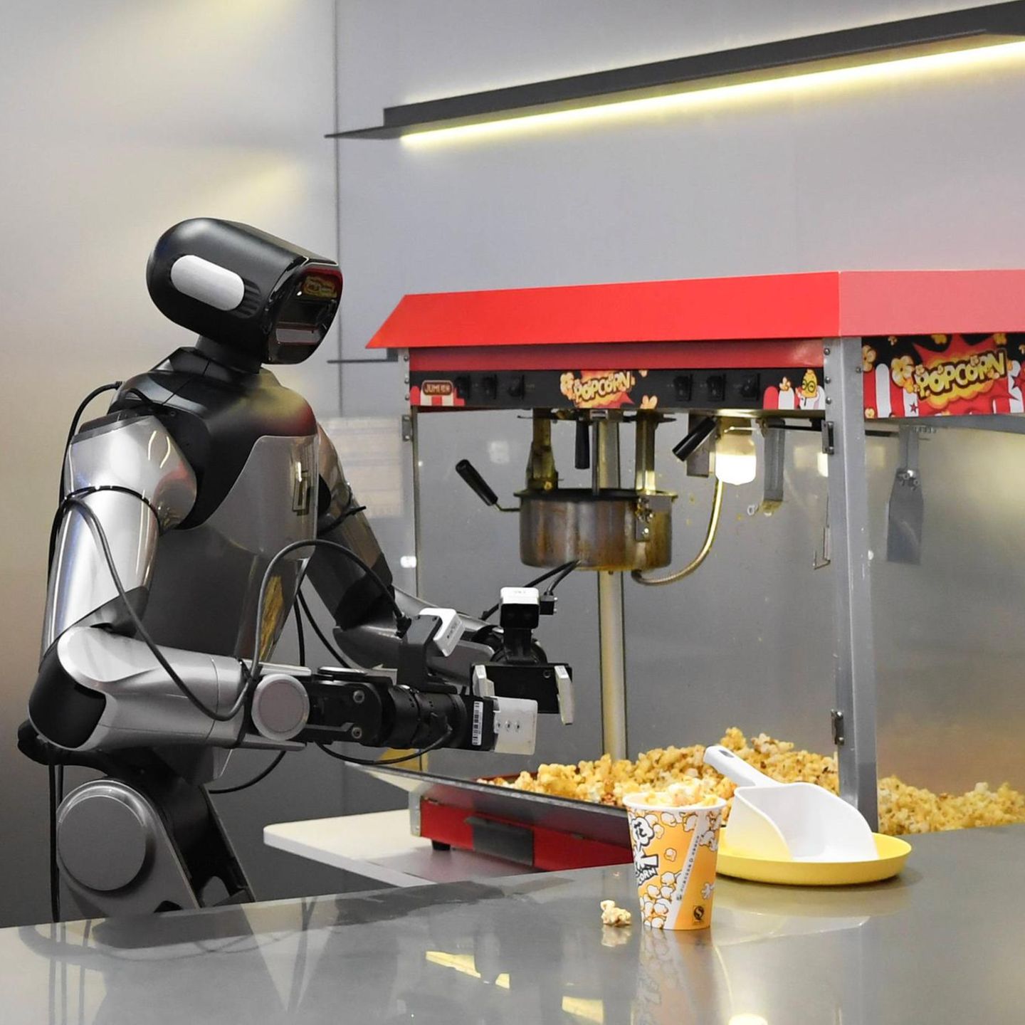 Hangzhou, China. Ein Roboter bereitet für die Besucher einer Ausstellungshalle der chinesischen „nationalen Pilotbasis für verkörperte KI“ vollautomatisiert Popcorn zu. Die Forschungsbasis im ostchinesischen Hangzhou ist eine der wichtigsten für Künstliche Intelligenz. Hier sind derzeit mehr als 130 Roboter in 30 beruflichen Szenarios eingesetzt, die eigentlich von Menschen übernommen werden. Darunter Gastronomie, Einzelhandel und Obsternten.
