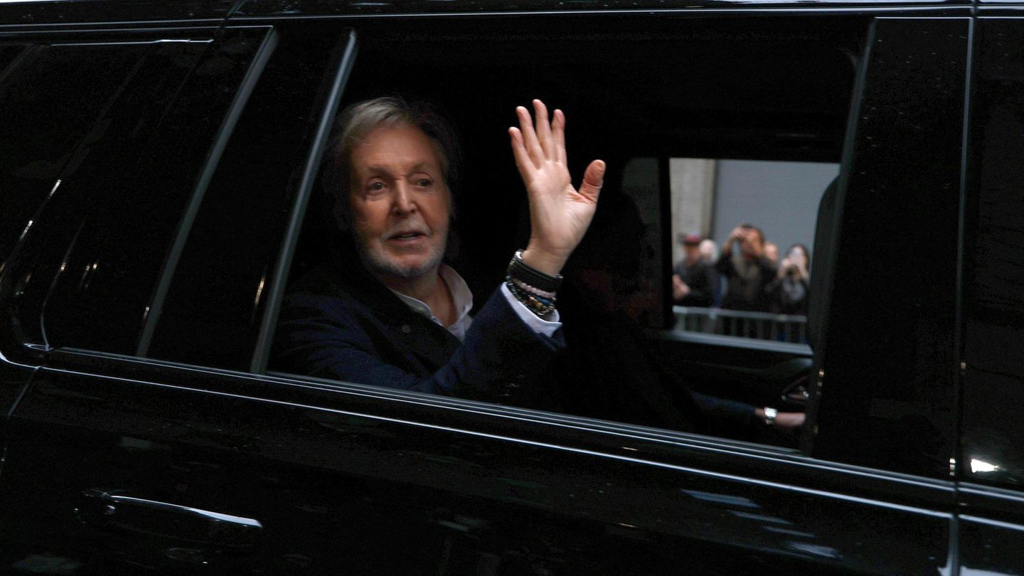 Paul McCartney winkt aus einer Limousine