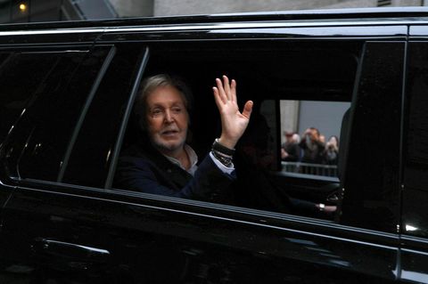 Paul McCartney winkt aus einer Limousine