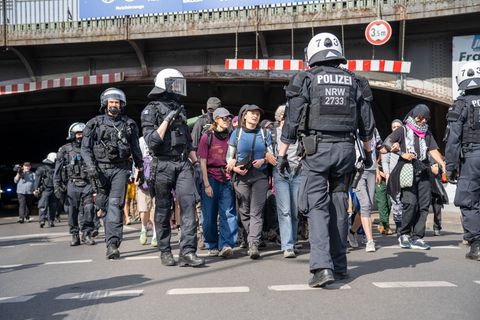 Polizisten schirmen Demonstranten bei einer Versammlung ab. Foto: Max Lametz/dpa