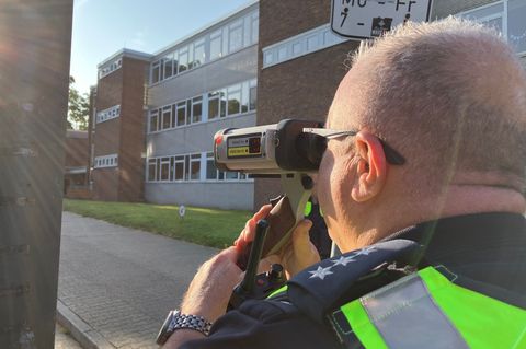 Ein Polizist ist bei einer Geschwindigkeitskontrolle vor einer Grundschule zu sehen. (Archivbild) Foto: Volker Danisch/dpa