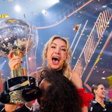 Die Siegerin jubelt und hält einen Disco-Pokal in den Händen, ihr Tanzpartner hebt sie hoch
