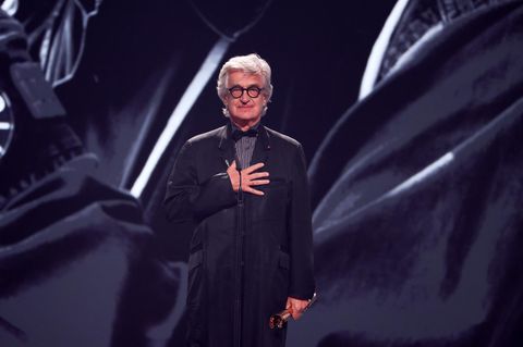 Wim Wenders hält sich beim Deutschen Filmpreis 2026 die eine Hand ans Herz und hält in der anderen eine Lola