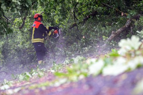 Die Feuerwehr räumt die bayerischen Straßen nach dem Unwetter wieder frei. Foto: Pia Bayer/dpa
