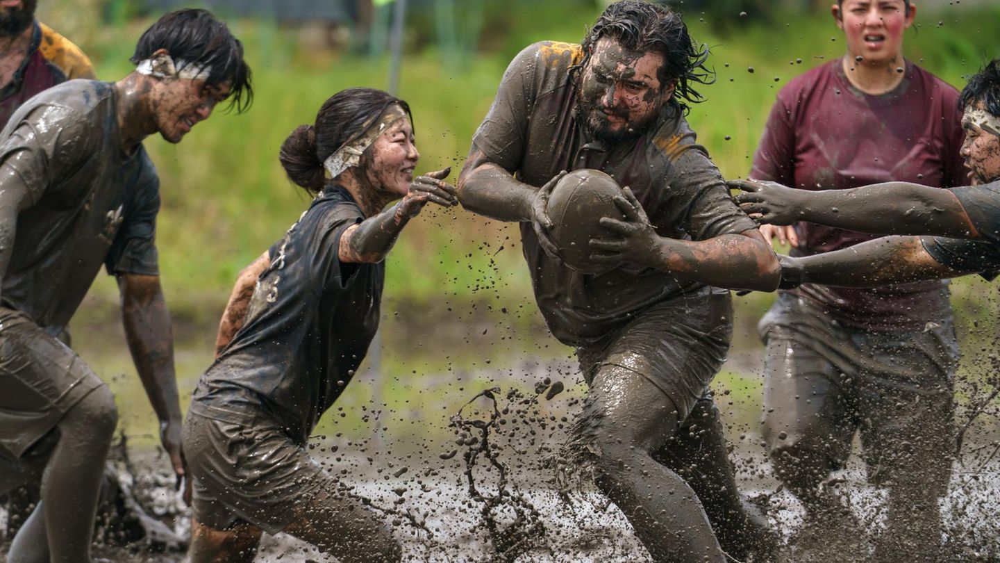 Fujimi, Japan. Sportler spielen Rugby auf einem schlammigen Reisfeld. Der Sieger wird anhand der kombinierten Punktzahlen aller Spiele ermittelt. Rugby-Spiele mit jeweils vier Spielern, die vor der Pflanzsaison auf Reisfeldern ausgetragen werden, erfreuen sich in Japan zunehmender Beliebtheit – als eine Form des gesellschaftlichen Engagements und der regionalen Revitalisierung.