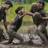 Fujimi, Japan. Sportler spielen Rugby auf einem schlammigen Reisfeld. Der Sieger wird anhand der kombinierten Punktzahlen aller Spiele ermittelt. Rugby-Spiele mit jeweils vier Spielern, die vor der Pflanzsaison auf Reisfeldern ausgetragen werden, erfreuen sich in Japan zunehmender Beliebtheit – als eine Form des gesellschaftlichen Engagements und der regionalen Revitalisierung.
