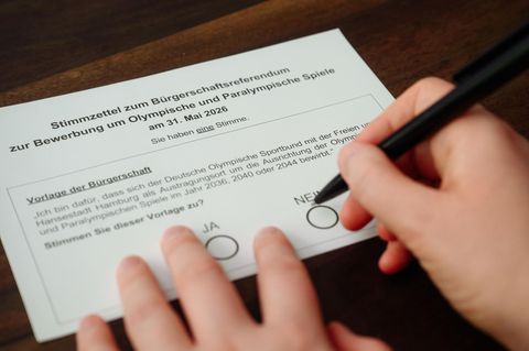 Eine Hand mit einem Kugelschreiber über einem Abstimmungszettel zur Olympia-Bewerbung von Hamburg