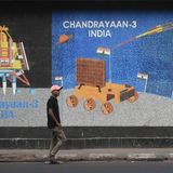 Ein Mann geht an einem Wandmosaik vorbei, auf dem das indische Raumfahrtprogramm zu sehen ist