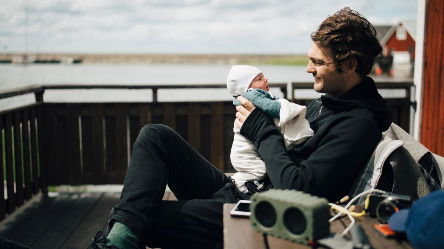 Elterngeld: Mann hält ein Baby im Arm
