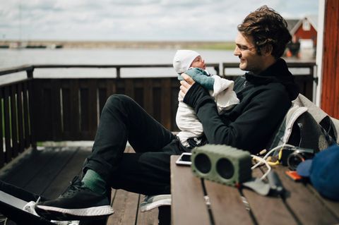 Elterngeld: Mann hält ein Baby im Arm