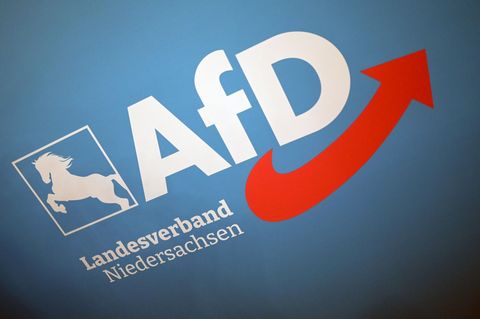 Das Logo des AfD Landesverband Niedersachsen hängt an einer Wand im Saal