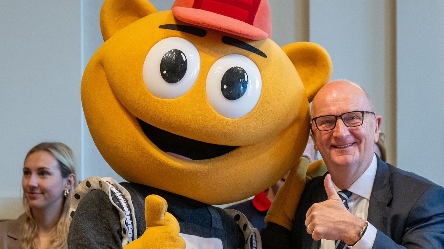 Das Filmpark-Maskottchen „Flimmy“ bringt Brandenburgs Ministerpräsidenten Dietmar Woidke beim Kindertagsfest in der Staatskanzle