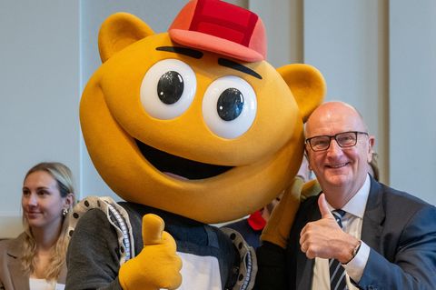 Das Filmpark-Maskottchen „Flimmy“ bringt Brandenburgs Ministerpräsidenten Dietmar Woidke beim Kindertagsfest in der Staatskanzle