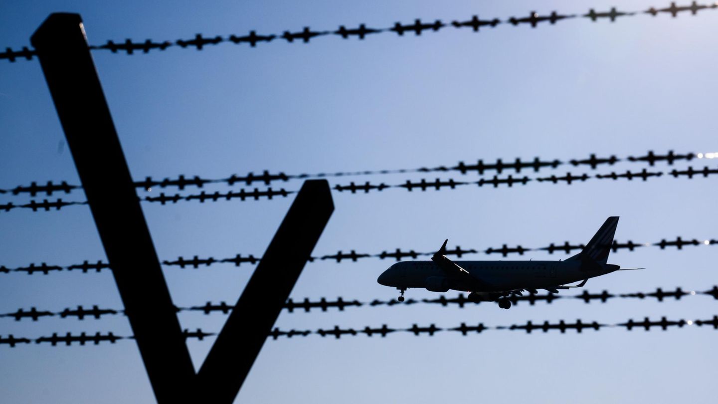Ein Flugzeug fliegt hinter Stacheldraht am Flughafen Hannover