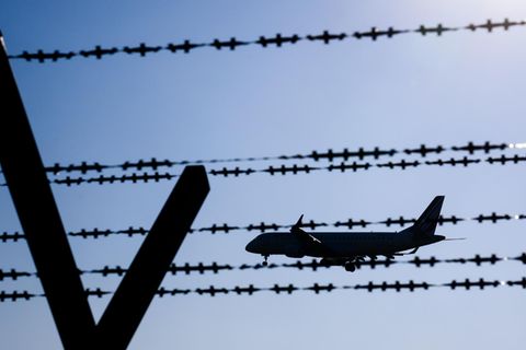 Ein Flugzeug fliegt hinter Stacheldraht am Flughafen Hannover