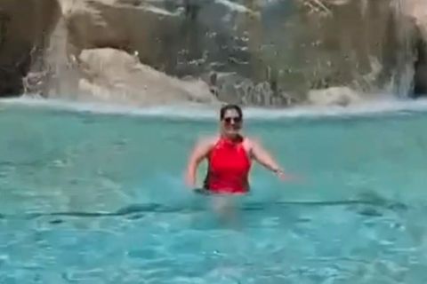 Touristin im Trevi-Brunnen in Rom