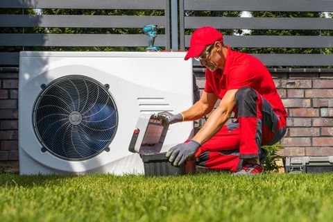 Ein Handwerker arbeitet an einer Wärmepumpe