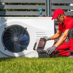 Ein Handwerker arbeitet an einer Wärmepumpe