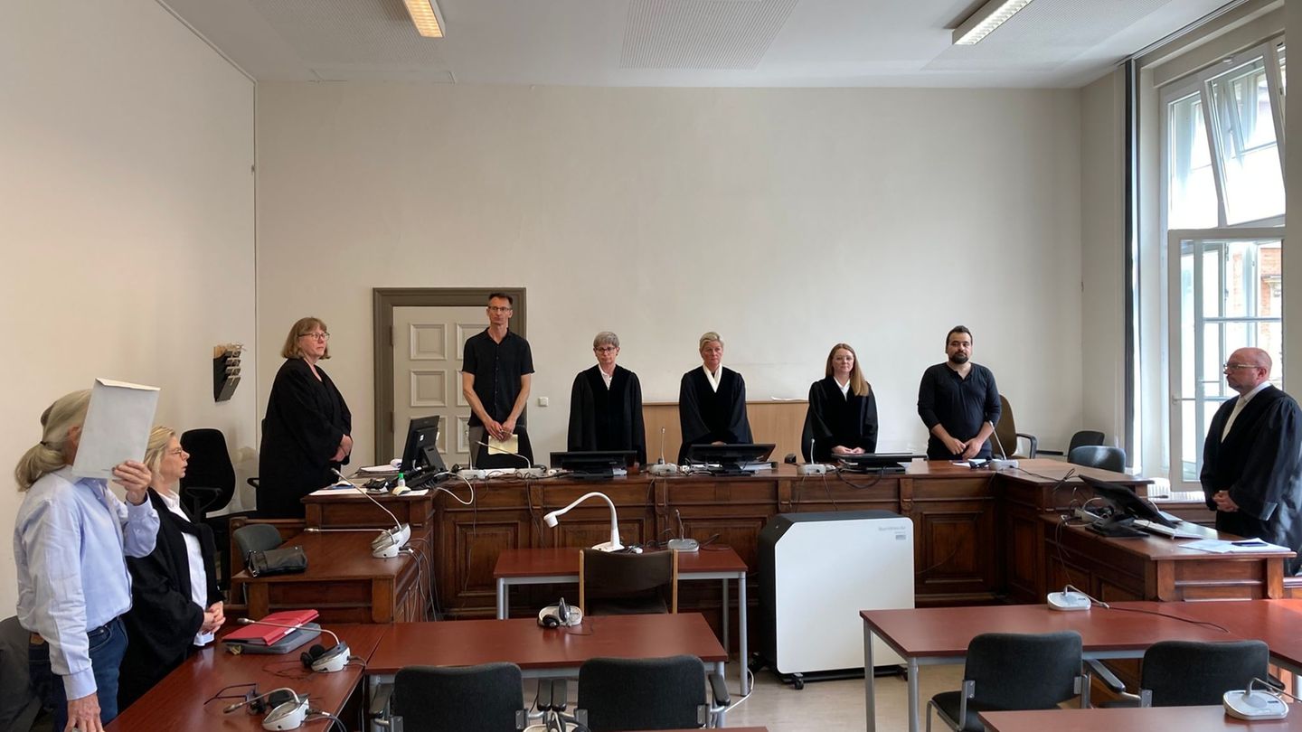 Der Angeklagte steht zu Beginn des Prozesses um versuchten Mord vor der Großen Strafkammer und verdeckt sein Gesicht vor den Pre
