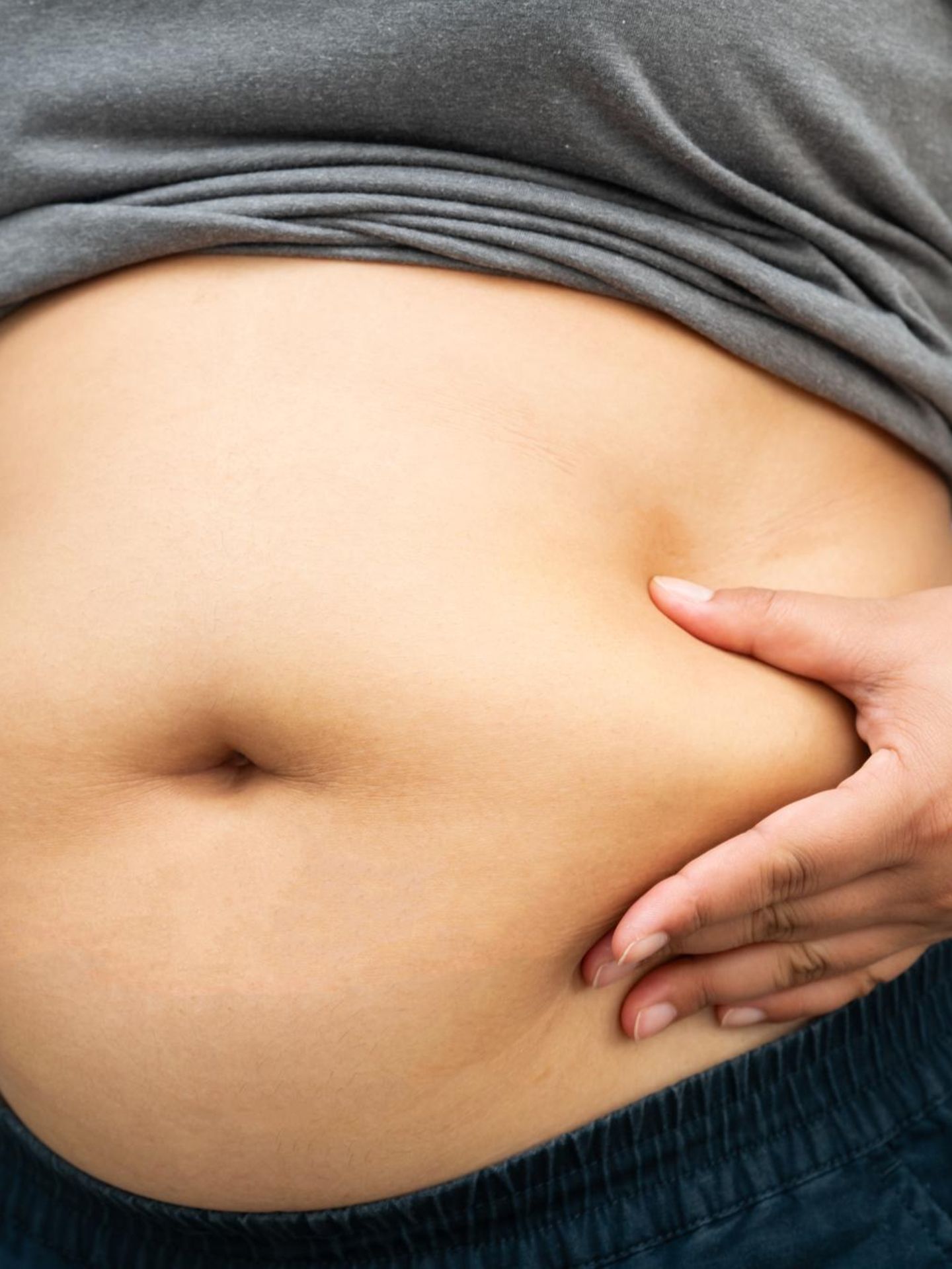 Abnehmpille: Frau hält ihren Bauch
