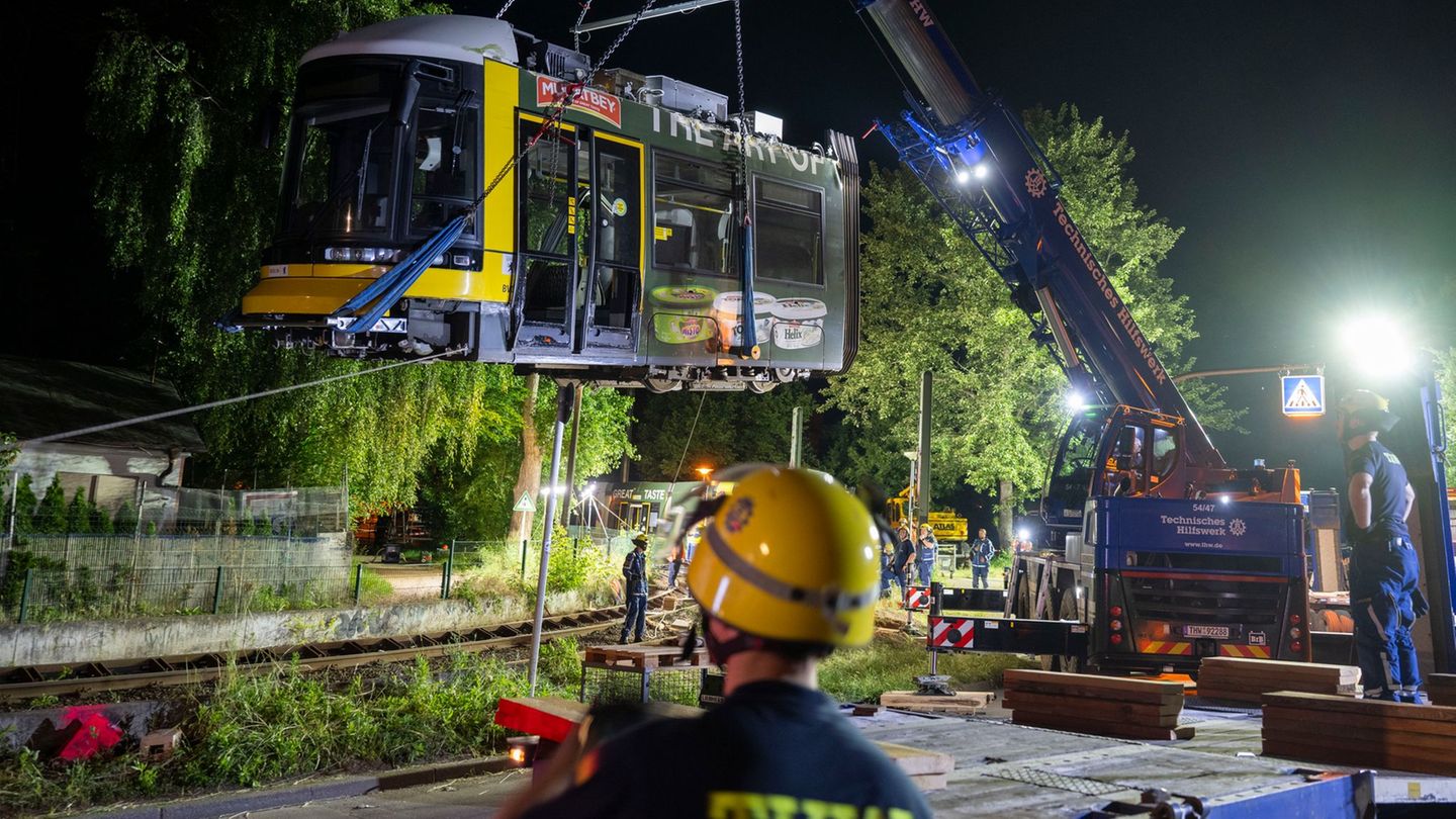 Ein Kran hebt die Straßenbahn aus dem Gleis. Foto: Christophe Gateau/dpa