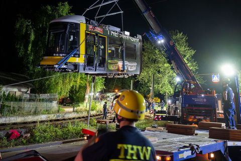 Ein Kran hebt die Straßenbahn aus dem Gleis. Foto: Christophe Gateau/dpa
