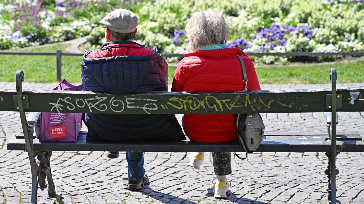 Ein äteres Ehepaar sitzt auf einer Bank
