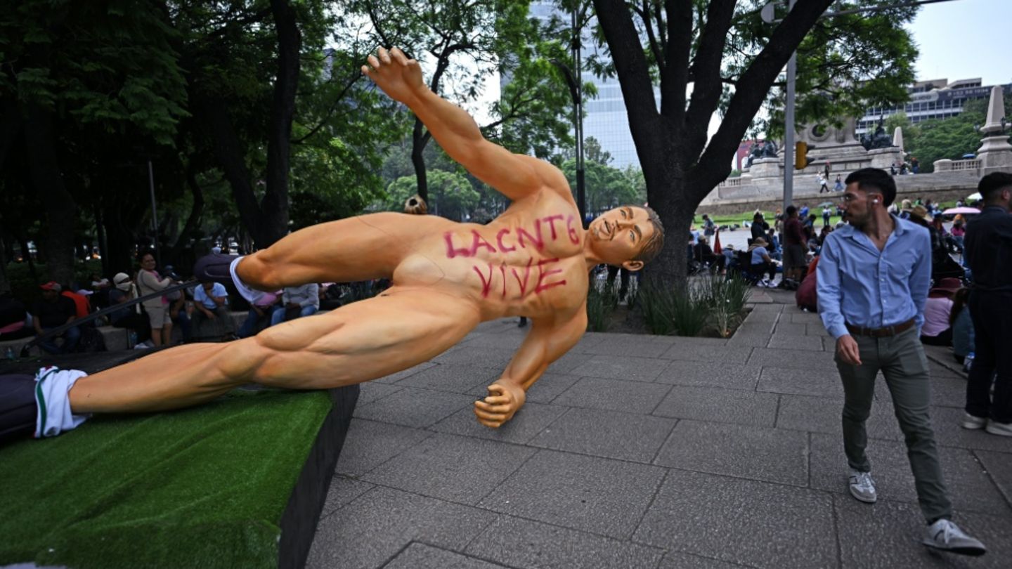 Von Demonstranten umgerissene riesige Fußballer-Figur