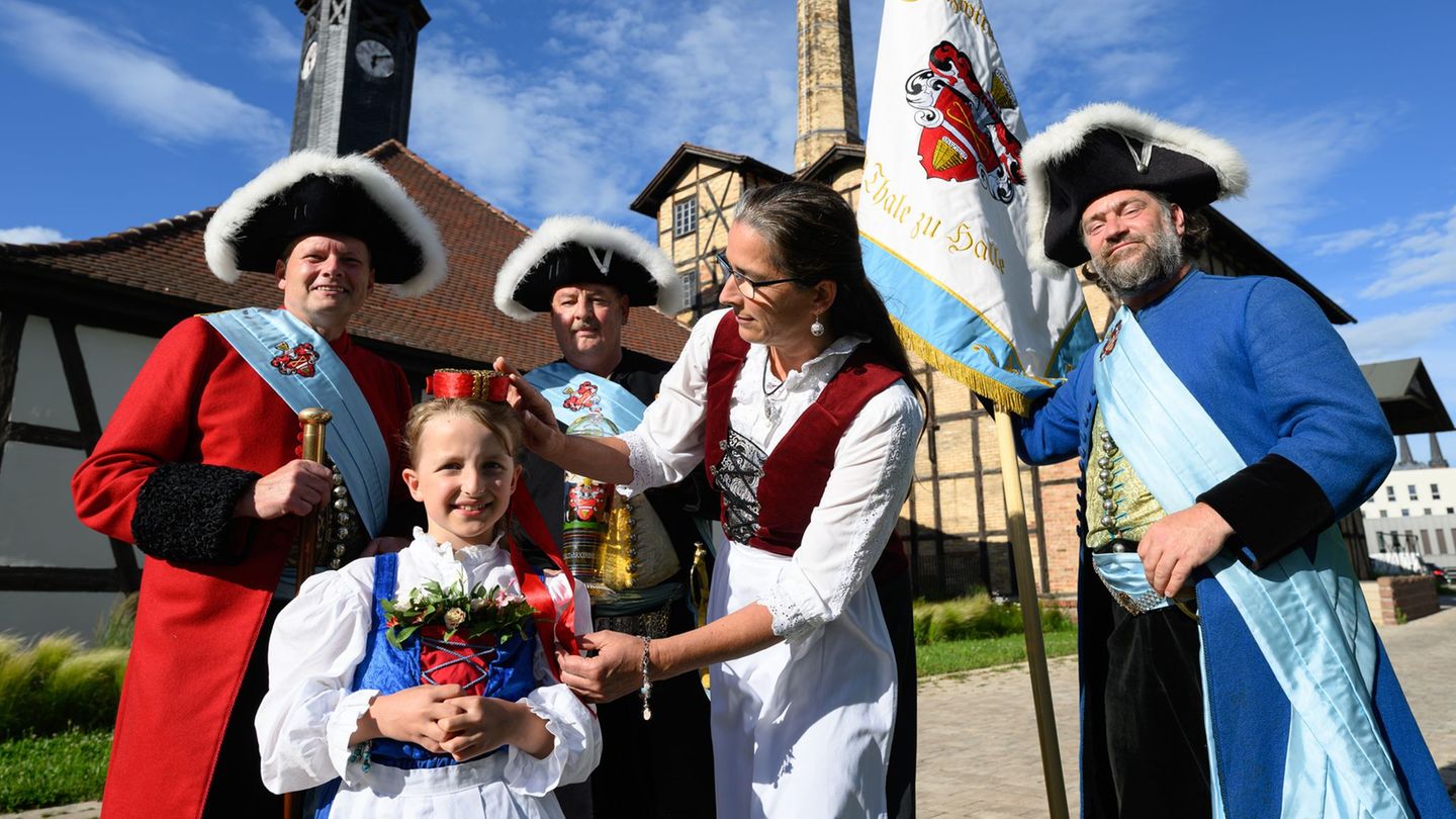 Vor der historischen Saline geben Hauptmann Uwe Frosch (l-r), Hallorenbraut Finja, Tobias Heinicke, Erster und Regierender Vorst