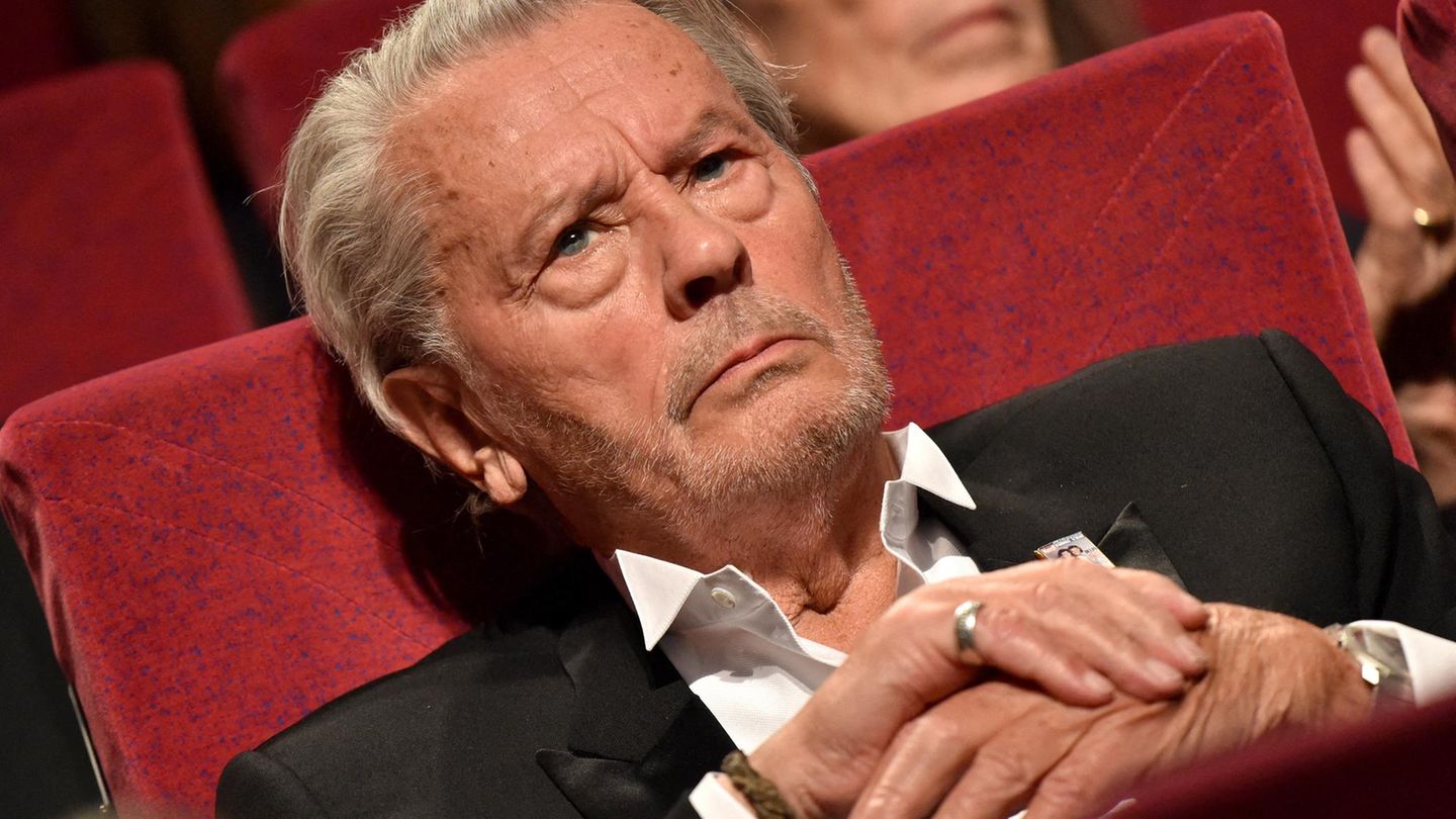 Alain Delon sitzt in einem Kinosessel