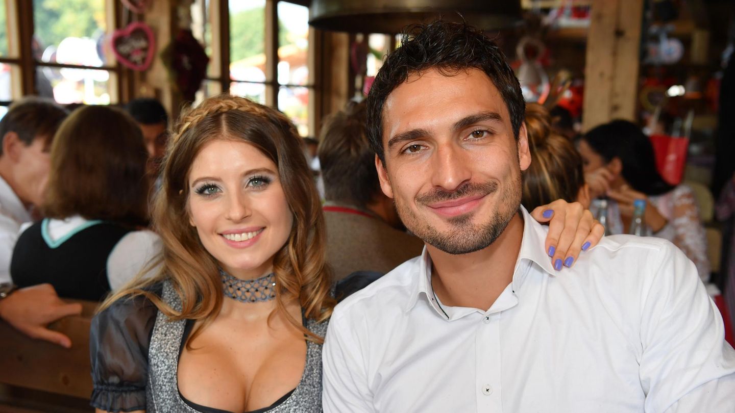 Mats und Cathy Hummels sitzen nebeneinander und lachen in die Kamera