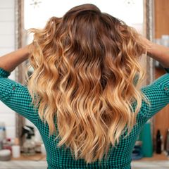 Eine Frau von hinten mit offenem, voluminösen Haar